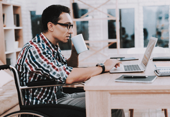 A man writes a letter of interest on his laptop while sipping a cup of tea