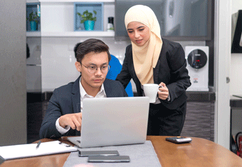 A job seeker writes his cover letter with the assistance of a friend