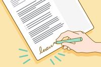 A hand signing a cover letter.