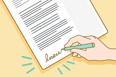 A hand signing a cover letter.