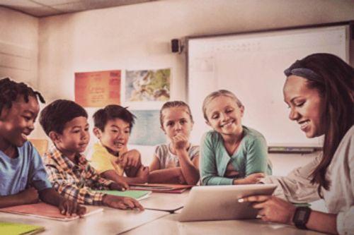 teacher in a classroom after getting a job because of her strong teacher resume objective