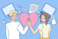 2 U.S. coworkers holding hands in a workplace setting